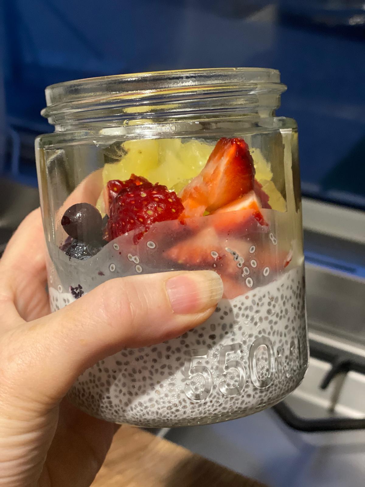 Chia pudding jar layered with fresh strawberries, mango and blueberries